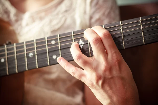 Close up on young woman's hand playing guitar — Stock Photo, Image