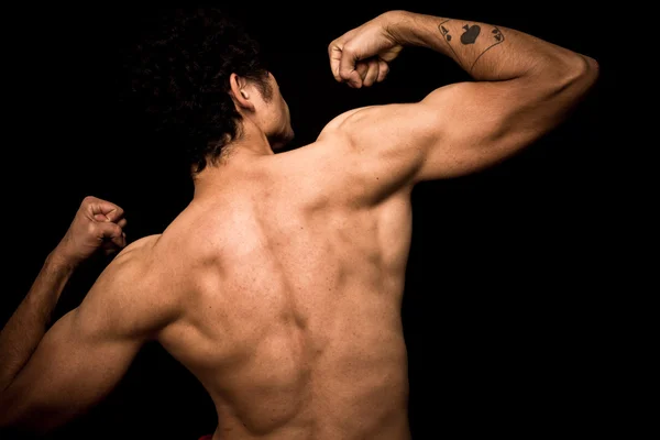 Young athletic shirtless man posing on black background — Stock Photo, Image