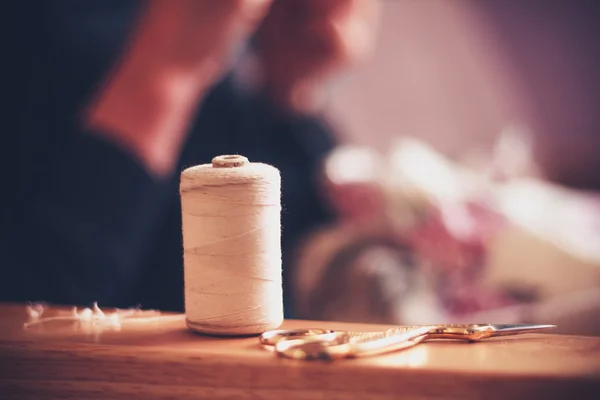 Wol en naaien apparatuur met vrouw in achtergrond — Stockfoto
