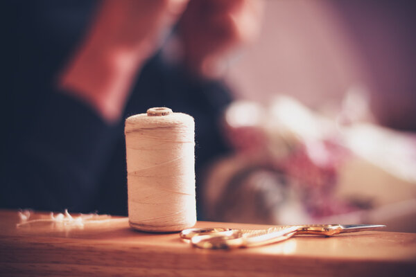 Thread and sewing equipment with woman in background