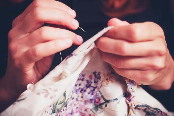 Close up on woman's hands sewing