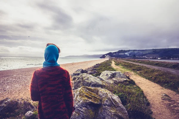 Mulher caminhando ao longo do caminho costeiro na praia no inverno — Fotografia de Stock