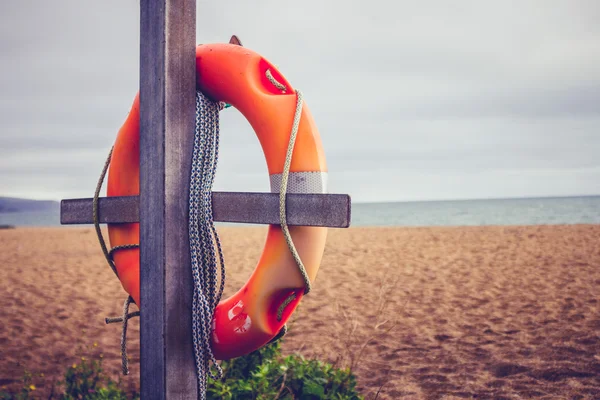 Life buoy on post at the beach — Stock Photo, Image