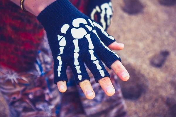 Woman wearing skeleton glove on the beach — Stock Photo, Image