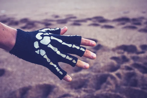 Vrouw skeleton handschoen dragen op het strand — Stockfoto