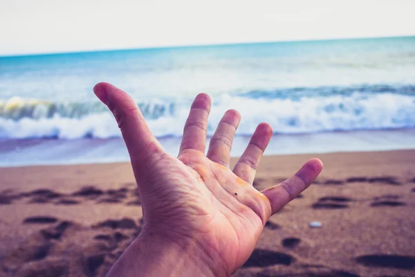 A mão aberta do homem na praia — Fotografia de Stock