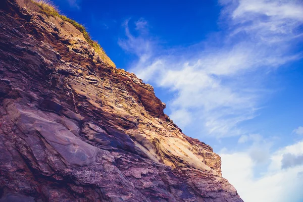 Rocky cliff side against blue sky — Stock Photo, Image