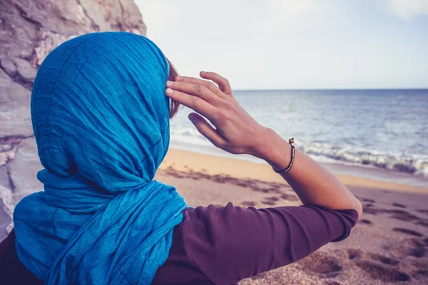 Vista trasera de mujer con pañuelo en la cabeza mirando al mar —  Fotos de Stock