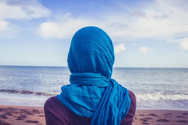 Vista trasera de mujer con pañuelo en la cabeza mirando al mar — Foto de Stock