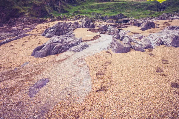 Stream of water on beach with near rural landscape — Stock Photo, Image