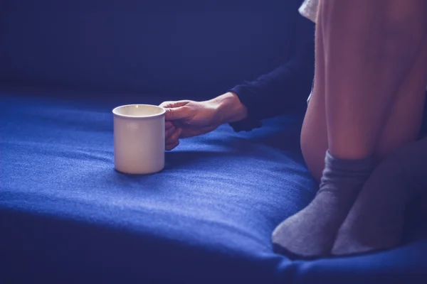 Mujer sentada en sofá bebiendo té —  Fotos de Stock