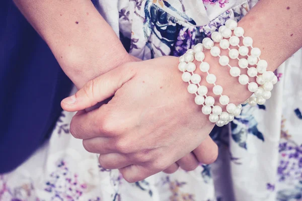 Mãos de mulher usando uma pulseira de pérola — Fotografia de Stock