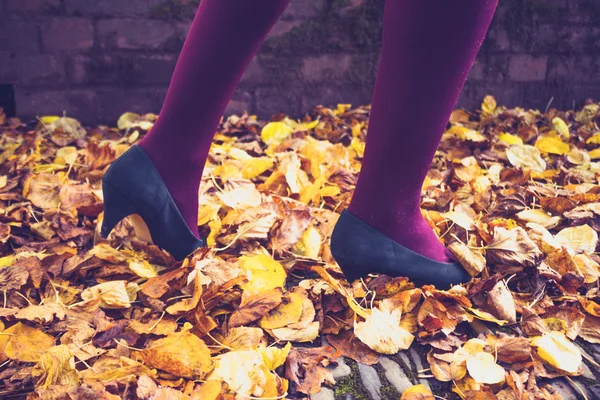 Woman walking through leaves — Stock Photo, Image