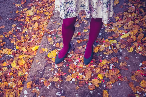 Femme debout parmi les feuilles et les confettis — Photo