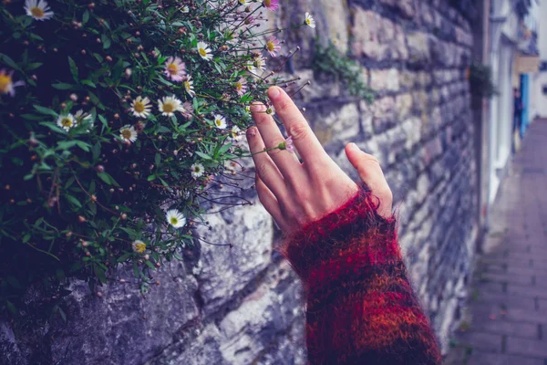 Femme touchant un vieux mur de pierre — Photo