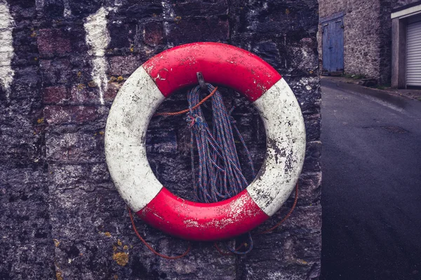 Life buoy on old stone wall — Stock Photo, Image