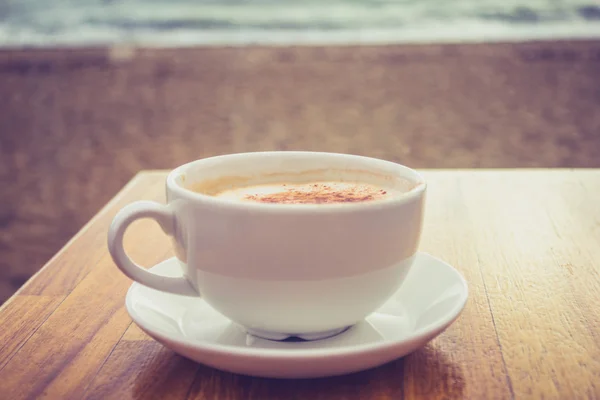 Kopje cappuccino door de zee — Stockfoto