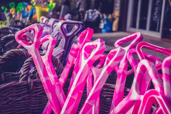 Panier avec des pelles en plastique colorées à la plage — Photo