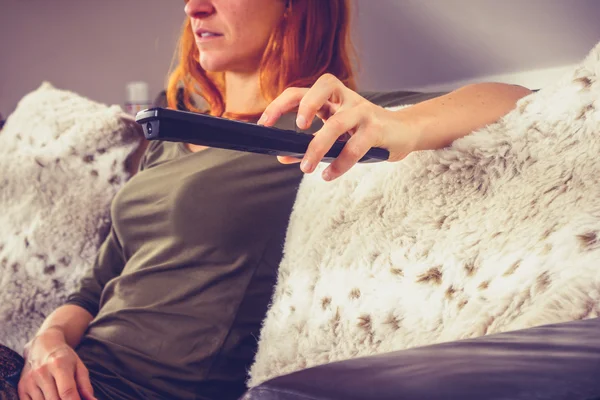 Žena se dívá na televizi doma — Stock fotografie