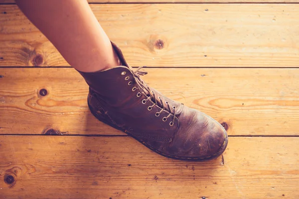 Bőr láb női csizma, a fa padló — Stock Fotó