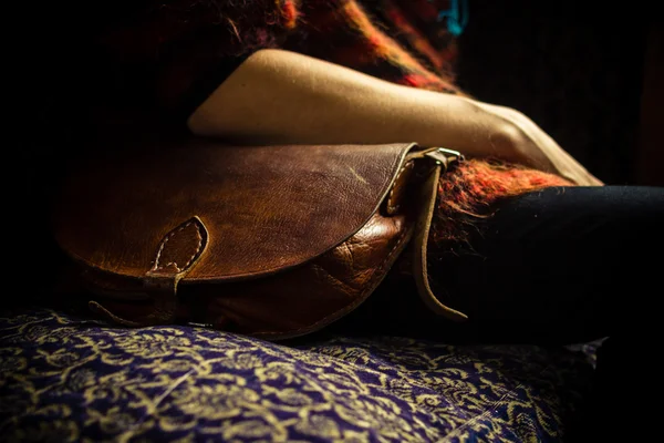 Donna con borsetta seduta su vecchio divano vintage — Foto Stock