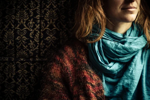 Молодая женщина с шарфом сидит на винтажном диване — стоковое фото