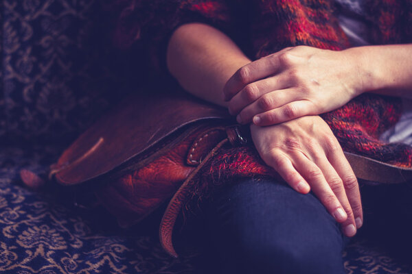 Woman with handbag sitting on old vintage sofa