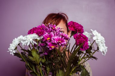 genç kadın bir buket çiçek saklanıyor