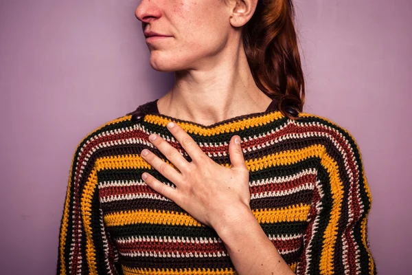 Young woman touching her chest — Stock Photo, Image