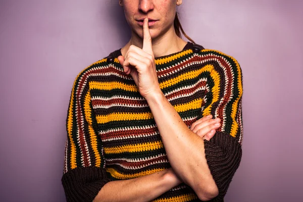 Jovem mulher gesticulando silêncio com o dedo no lábio — Fotografia de Stock