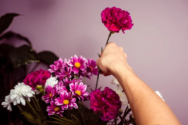 Jovem mulher organizando um buquê de flores — Fotografia de Stock