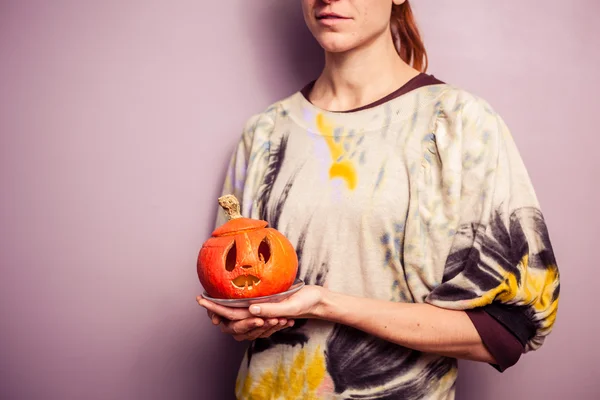 Giovane donna con in mano una spaventosa jack-o-lanterna — Foto Stock