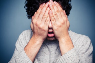 genç adam ellerini kafasına gizleme