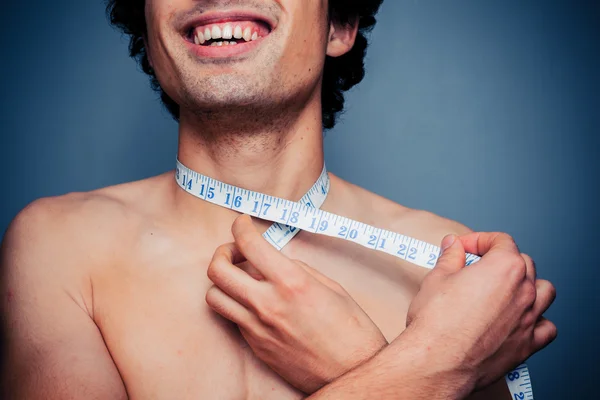 Jovem feliz está medindo seu pescoço — Fotografia de Stock