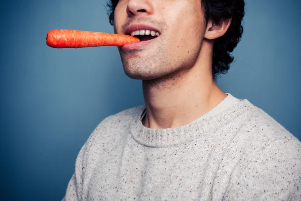 Νεαρός άνδρας τρώει ένα καρότο — Φωτογραφία Αρχείου