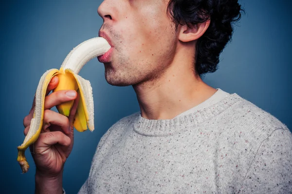 年轻男子吃香蕉 — 图库照片