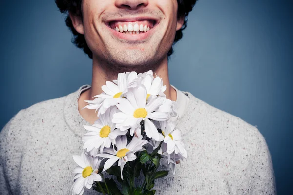 Счастливый молодой человек с цветами — стоковое фото