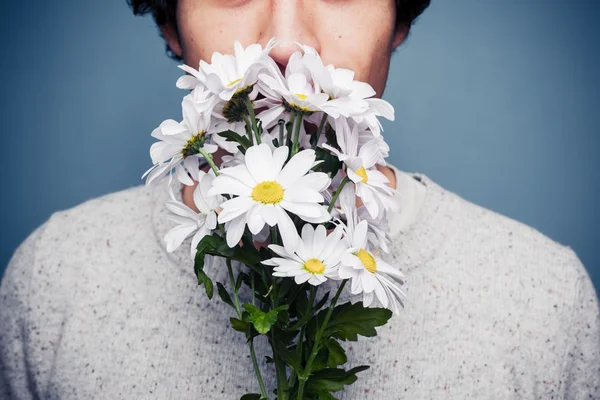 Giovane uomo che annusa un mazzo di fiori — Foto Stock