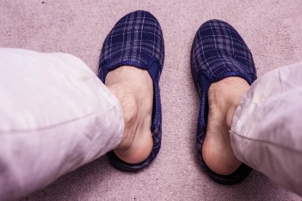Feet wearing slippers on carpet — Stock Photo, Image