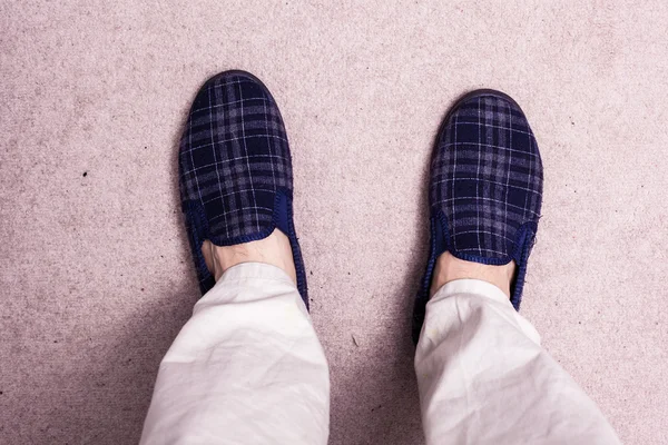 Feet wearing slippers on carpet — Stock Photo, Image