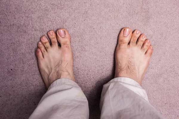 Os pés descalços do homem no tapete — Fotografia de Stock