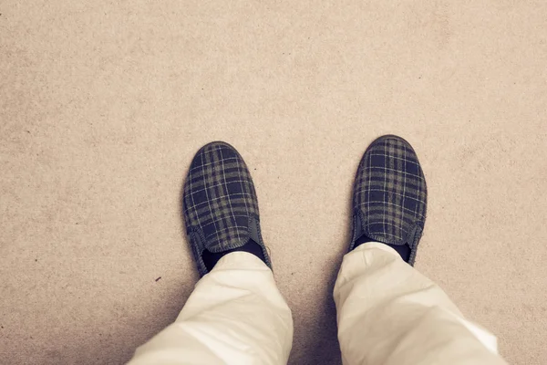 Piedi che indossano pantofole su tappeto — Foto Stock