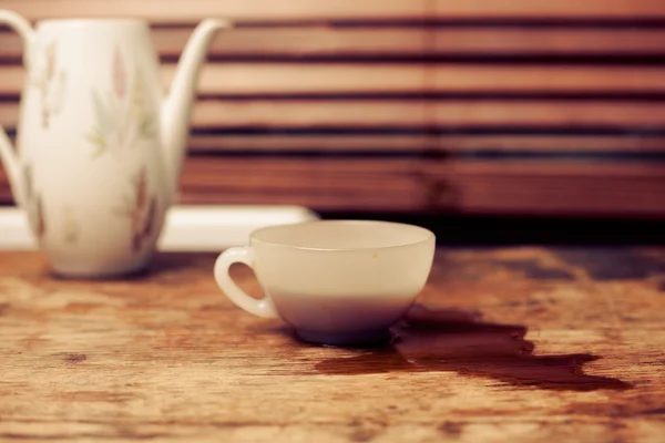 Xícara de café e panela por janela na mesa de madeira — Fotografia de Stock