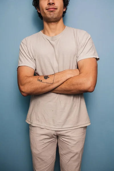 Gelukkig jonge tattoed man met gekruiste armen — Stockfoto