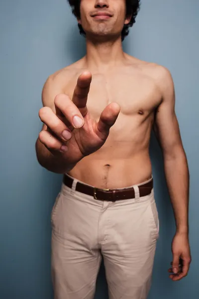 Jovem sem camisa apertando um botão — Fotografia de Stock