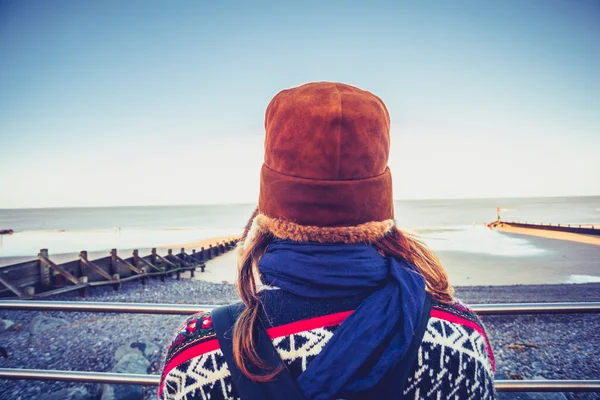 Rear view of woman in hat looking at sea — Stock Photo, Image