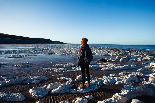 Ung kvinna beundrar stranden — Stockfoto