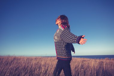Deniz kenarında çayırlarda çalışan genç bir kadın