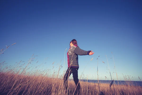 Jonge vrouw uiting van vrijheid in veld bij zonsondergang — Stockfoto