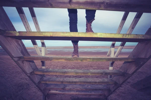 Hiker ascending steps to beach hut — Stock Photo, Image